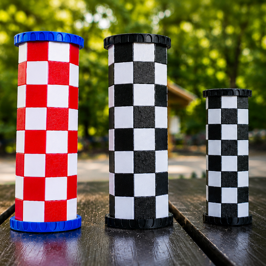 Travel chess set with checkered pieces on a wooden surface outdoors.