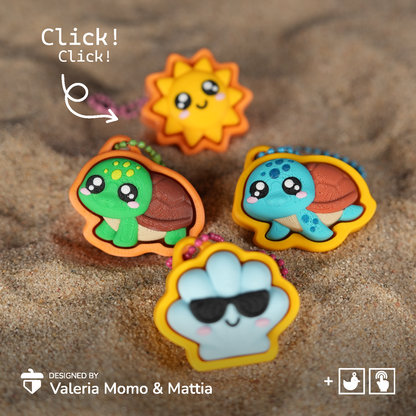 Three cute cartoon keychain charms shaped like a sun, a green turtle, and a blue turtle, displayed on a sandy surface with a 'Click! Click!' overlay and designer credit.