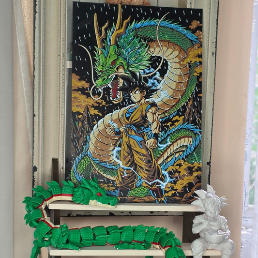 A green segmented robotic dragon curled around a rectangular black dragon figurine with a gold and blue body, displayed on a shelf next to a white dragon statue.